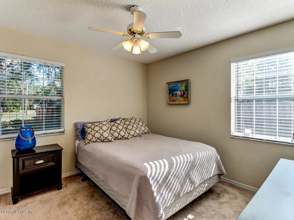 144 Tanager Road St. Augustine, FL 32086 - Photo 20 of 46 a bedroom with a bed and a chandelier