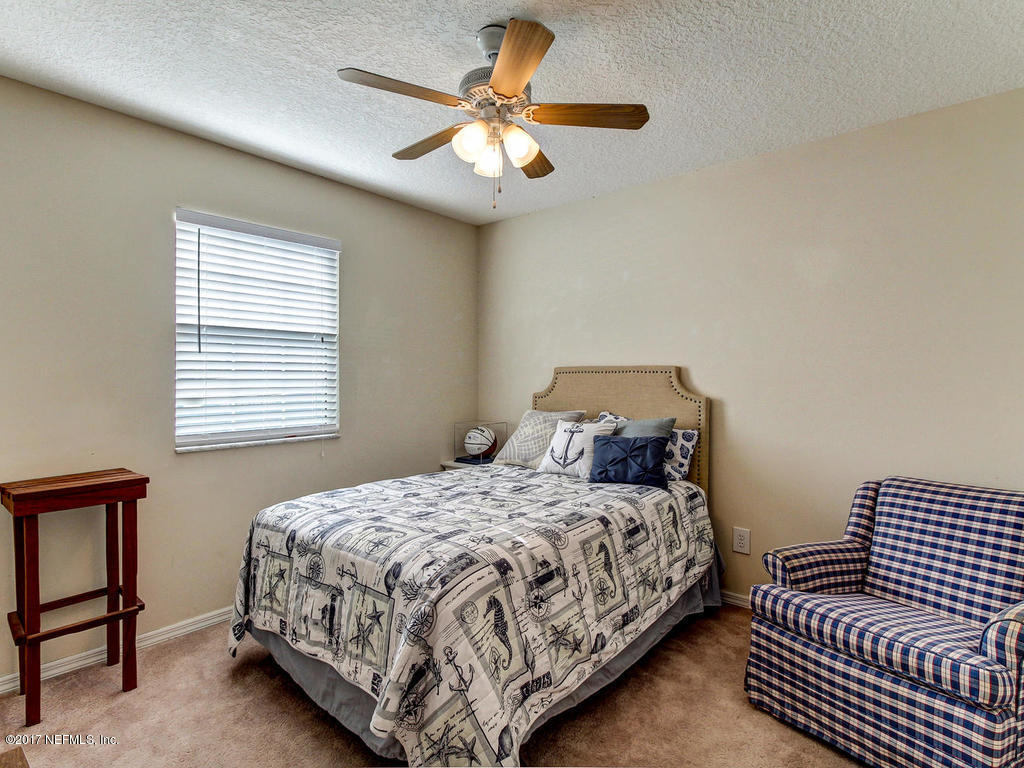 144 Tanager Road St. Augustine, FL 32086 - Photo 21 of 46 a bedroom with a bed and a chandelier