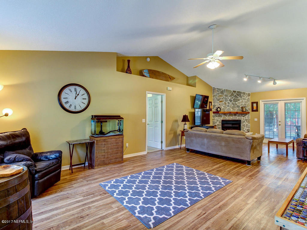144 Tanager Road St. Augustine, FL 32086 - Photo 5 of 46 a living room with furniture a clock on wall and a dining table