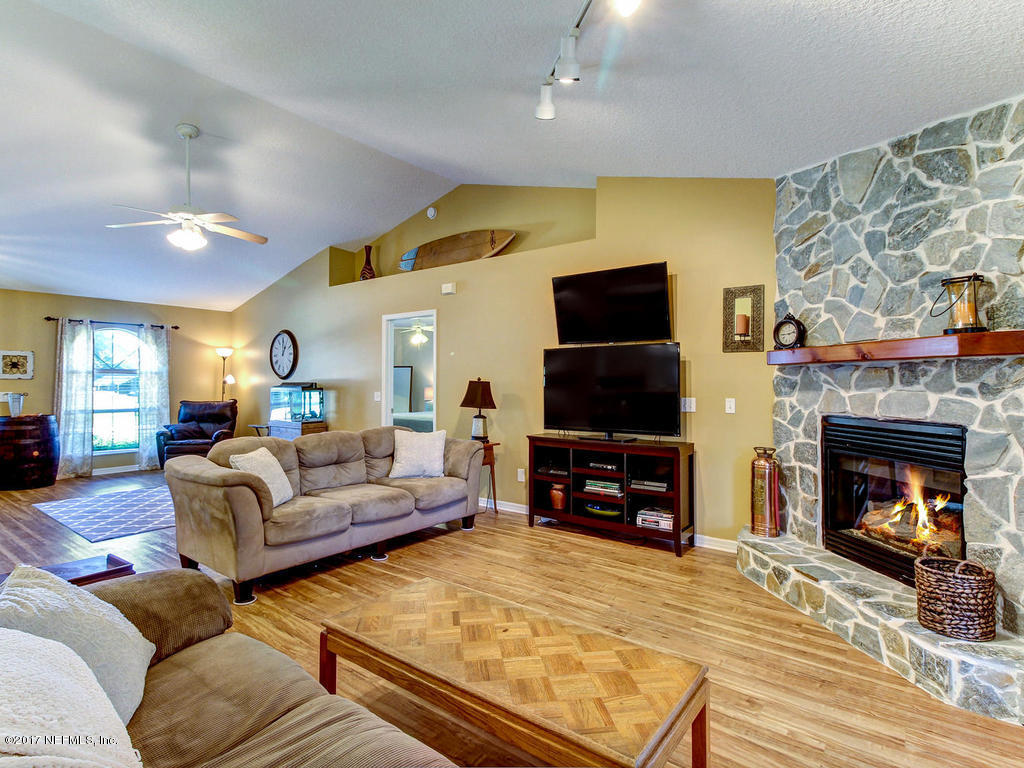144 Tanager Road St. Augustine, FL 32086 - Photo 7 of 46 a living room with furniture a flat screen tv and a fireplace