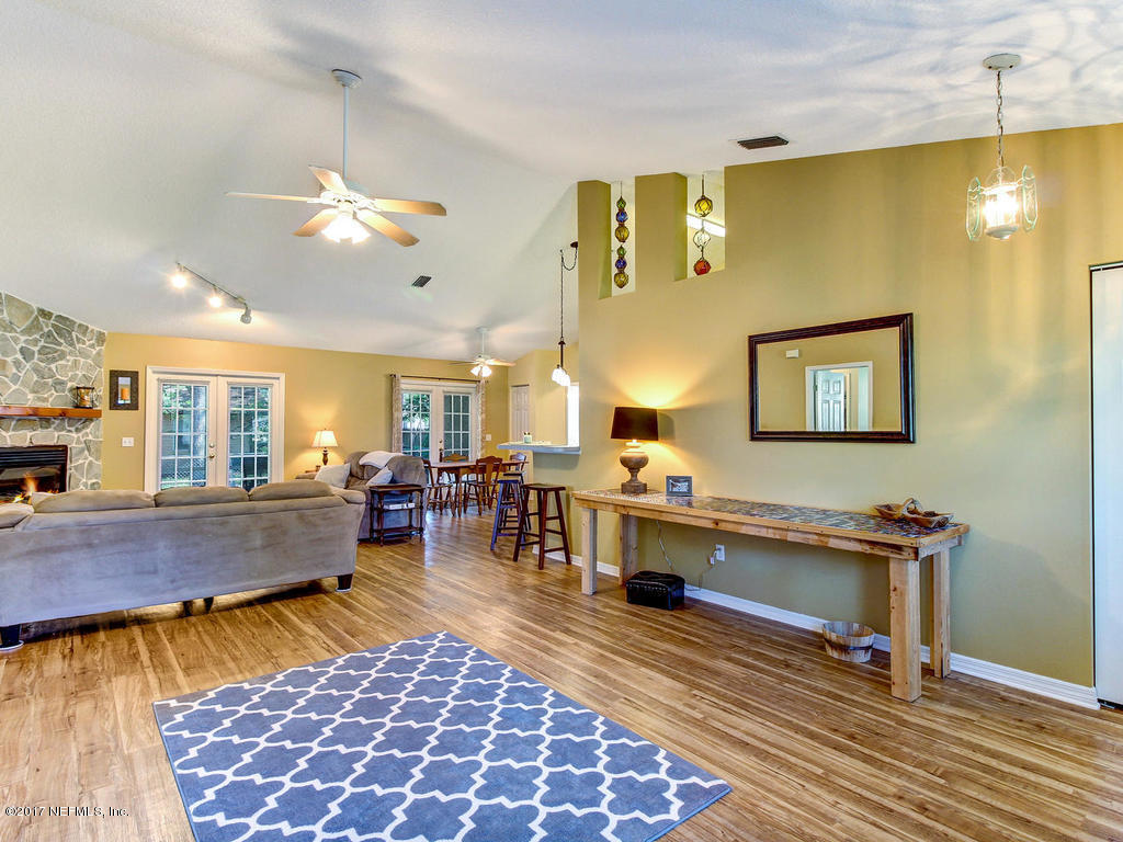 144 Tanager Road St. Augustine, FL 32086 - Photo 9 of 46 a living room with furniture a rug and a chandelier
