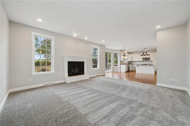 a view of an empty room with a window and fireplace