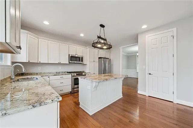 a kitchen with stainless steel appliances granite countertop a stove and cabinets
