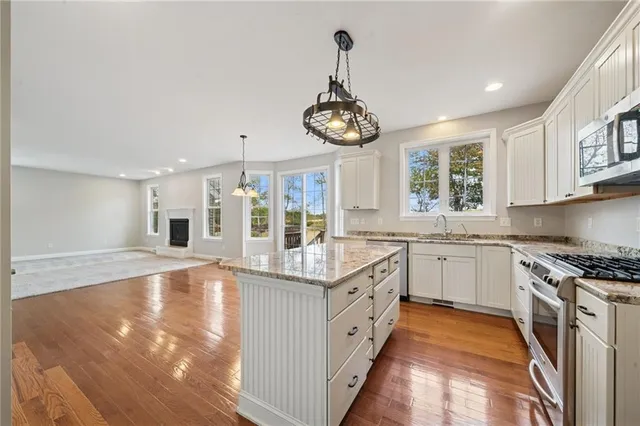 a kitchen with stainless steel appliances granite countertop a stove sink and cabinets