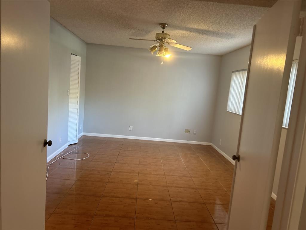 7680 Northwest 79th Avenue, Unit P1 Tamarac, FL 33321 - Photo 6 of 28 a view of an empty room with a chandelier fan