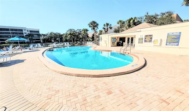 a view of a house with a yard and palm trees