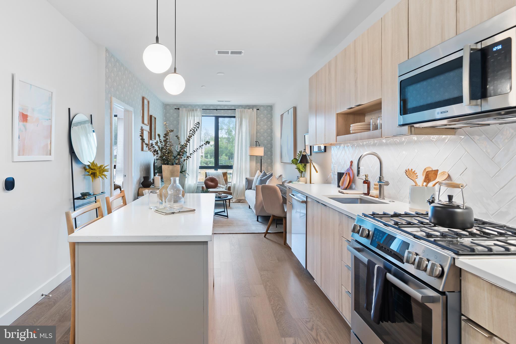 a kitchen with kitchen island granite countertop a sink a stove oven a counter space and cabinets