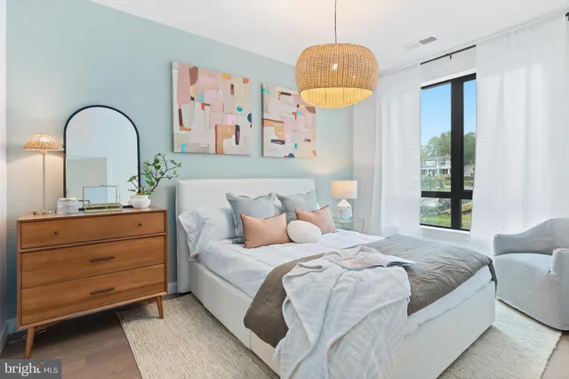 a bedroom with a bed and a painting on the wall