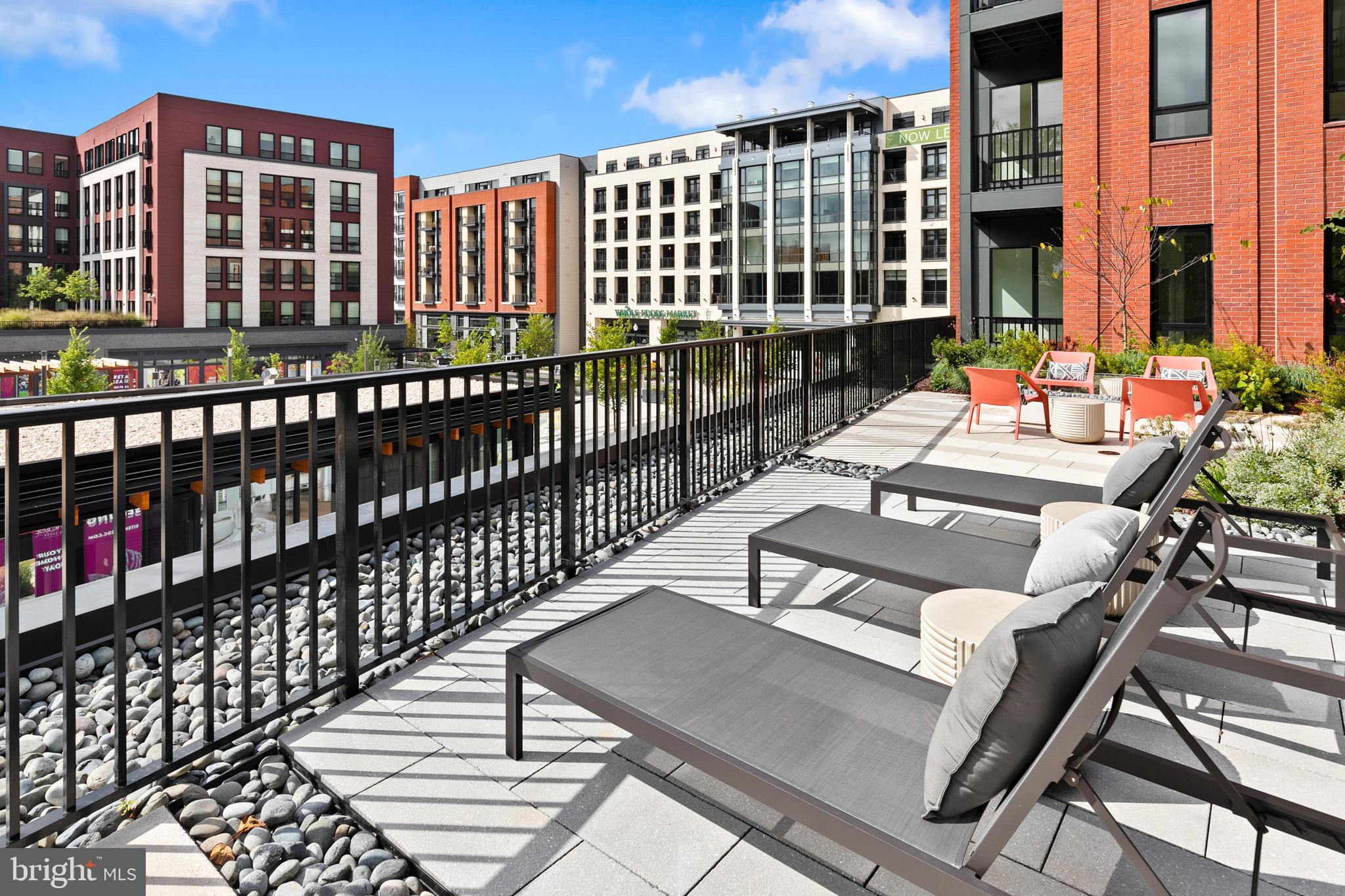 7175 12th Street Northwest, Unit 411 Washington, DC 20012 - Photo 41 of 46 a view of a balcony with wooden floor and outdoor seating