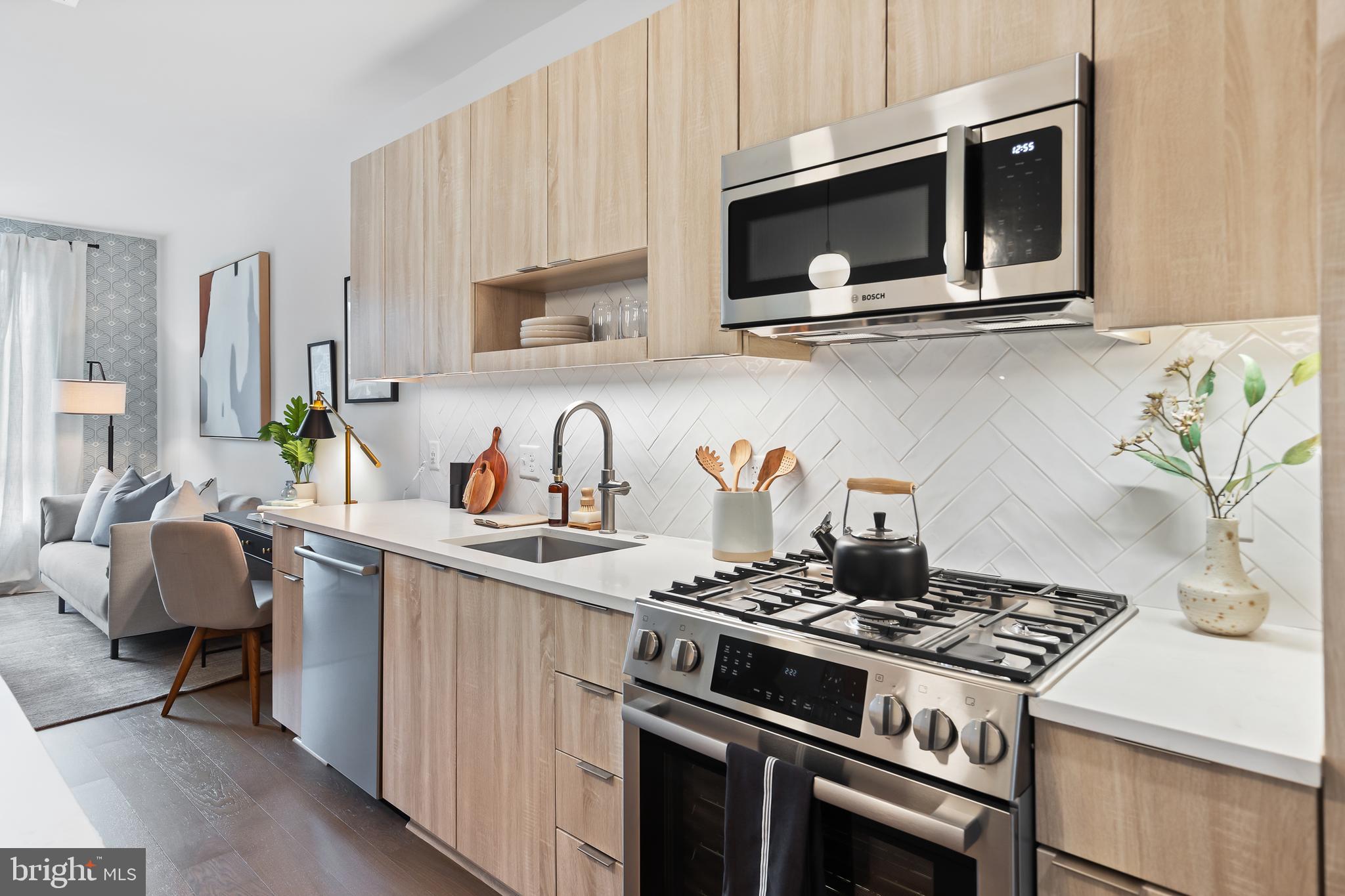 7175 12th Street Northwest, Unit 411 Washington, DC 20012 - Photo 8 of 46 a kitchen with stainless steel appliances a stove a microwave sink and cabinets