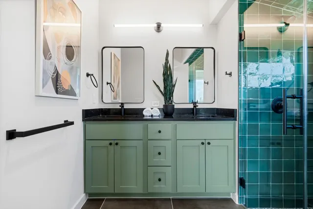 a bathroom with a granite countertop sink a mirror and shower