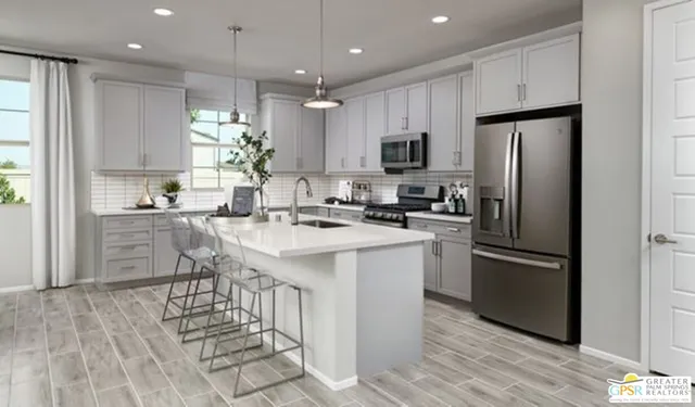 a kitchen with kitchen island granite countertop a refrigerator oven a sink dishwasher and white cabinets with wooden floor