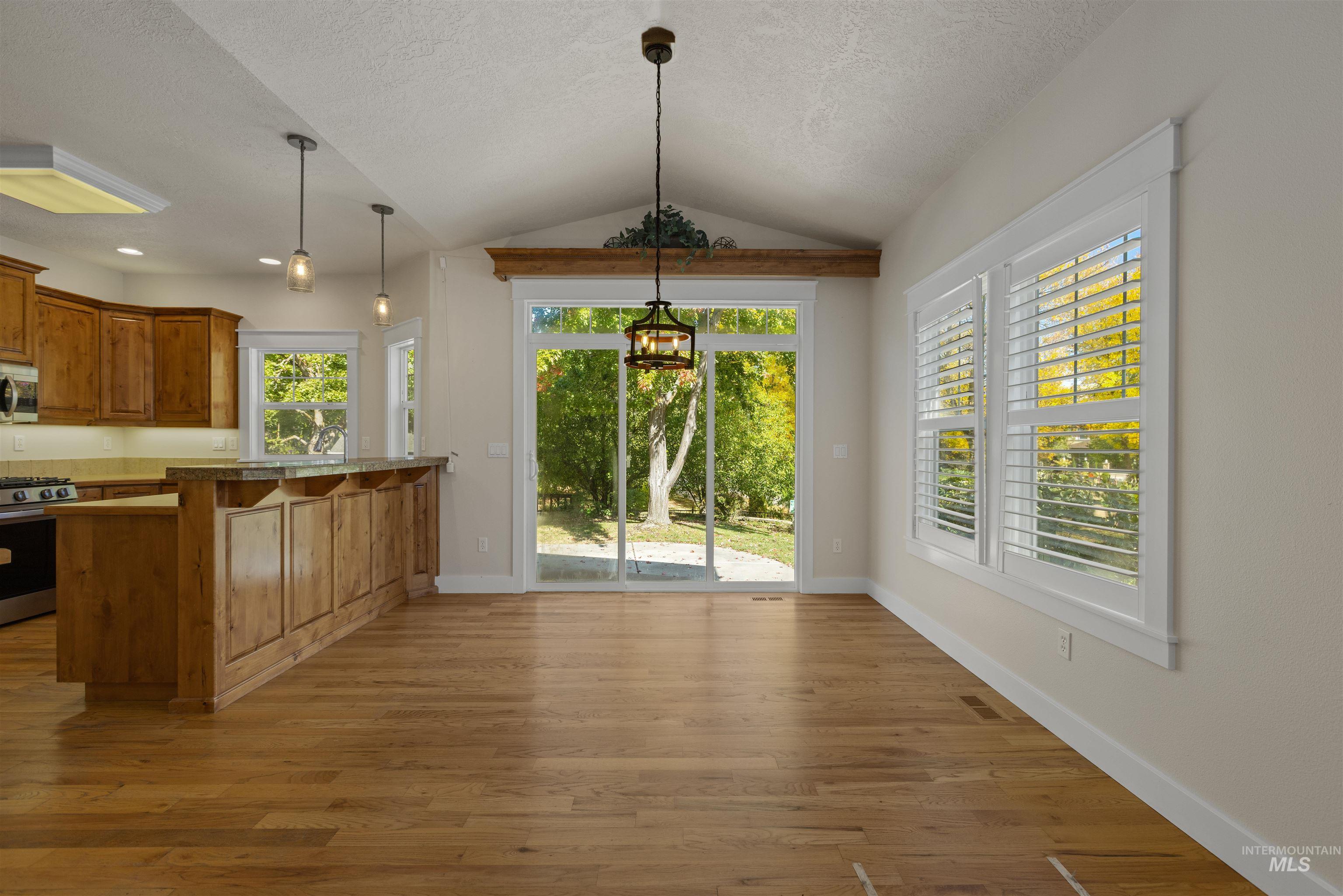 5426 West School Ridge Road Boise, ID 83714 - Photo 20 of 39 Vaulted ceiling, wood-finish flooring, sliding glass door, plantation shutters, and recessed lighting