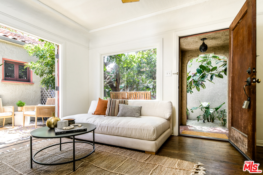 a living room with patio furniture and a potted plant