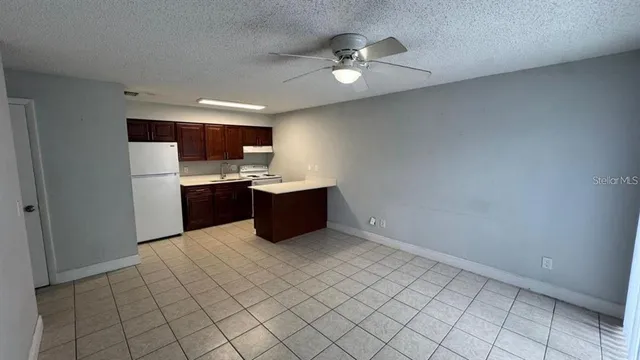 a view of kitchen with refrigerator and cabinets
