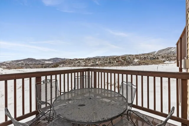 a balcony with wooden floor table and chair
