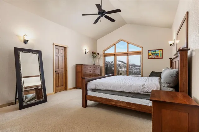 a bedroom with a bed a flat screen tv and a window