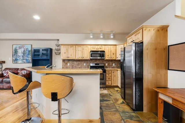 a kitchen with stainless steel appliances granite countertop a refrigerator and a stove top oven