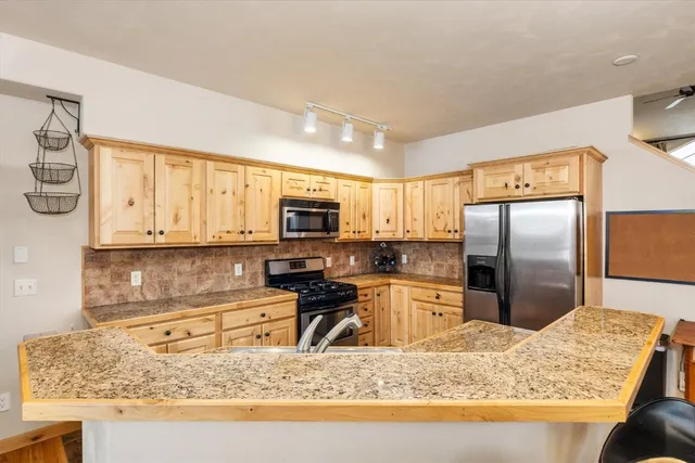 a kitchen with stainless steel appliances granite countertop a sink stove and refrigerator