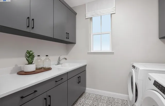 a utility room with cabinets washer and dryer