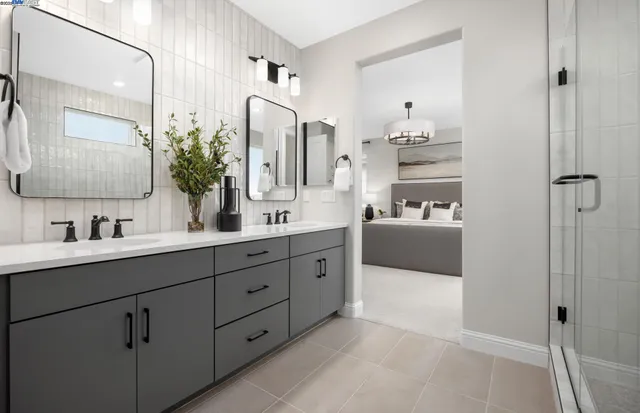 a spacious bathroom with a double vanity sink a mirror and shower