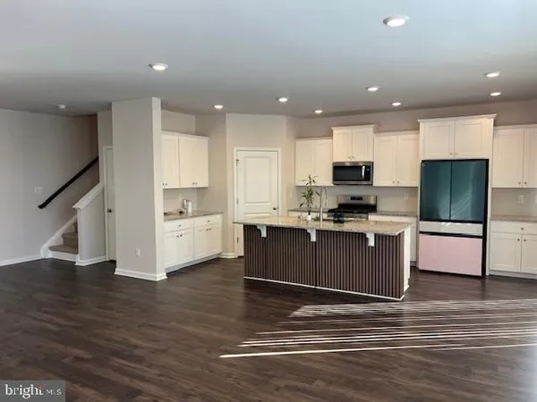 a kitchen with a refrigerator and a stove top oven