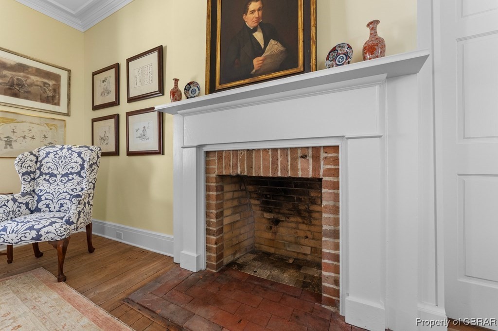 1701 Balls Neck Road Kilmarnock, VA 22482 - Photo 21 of 50 Living area with a fireplace, crown molding, and hardwood / wood-style flooring