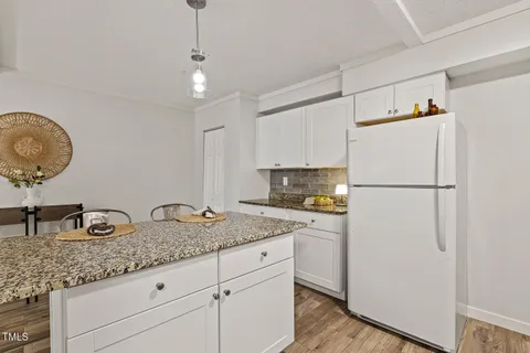 a kitchen with granite countertop a refrigerator a sink and dishwasher