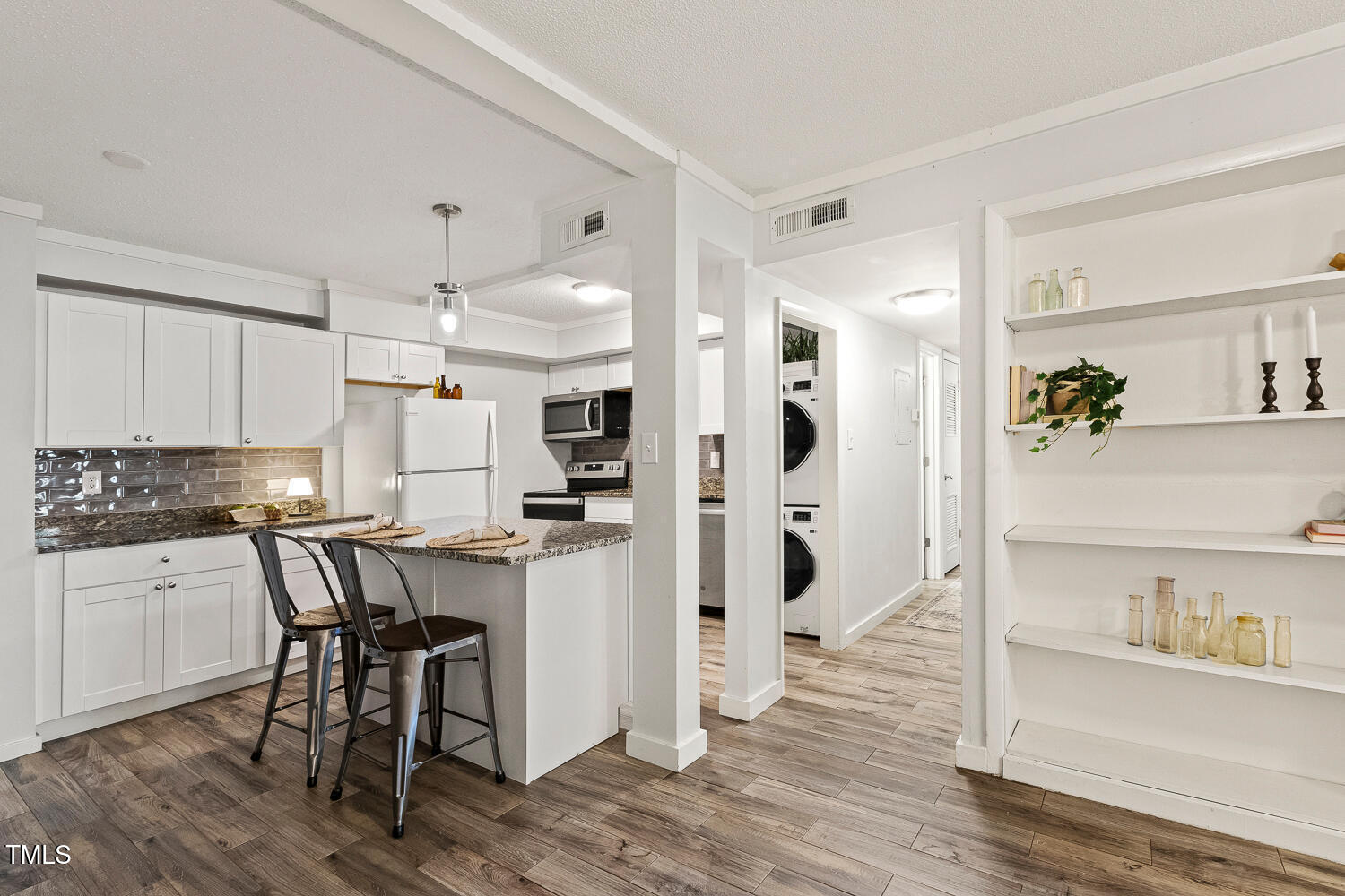 7002 Longstreet Drive, Unit C Raleigh, NC 27615 - Photo 16 of 31 a kitchen with stainless steel appliances a dining table chairs refrigerator and sink