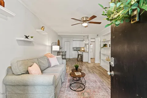 a living room with furniture and a wooden floor