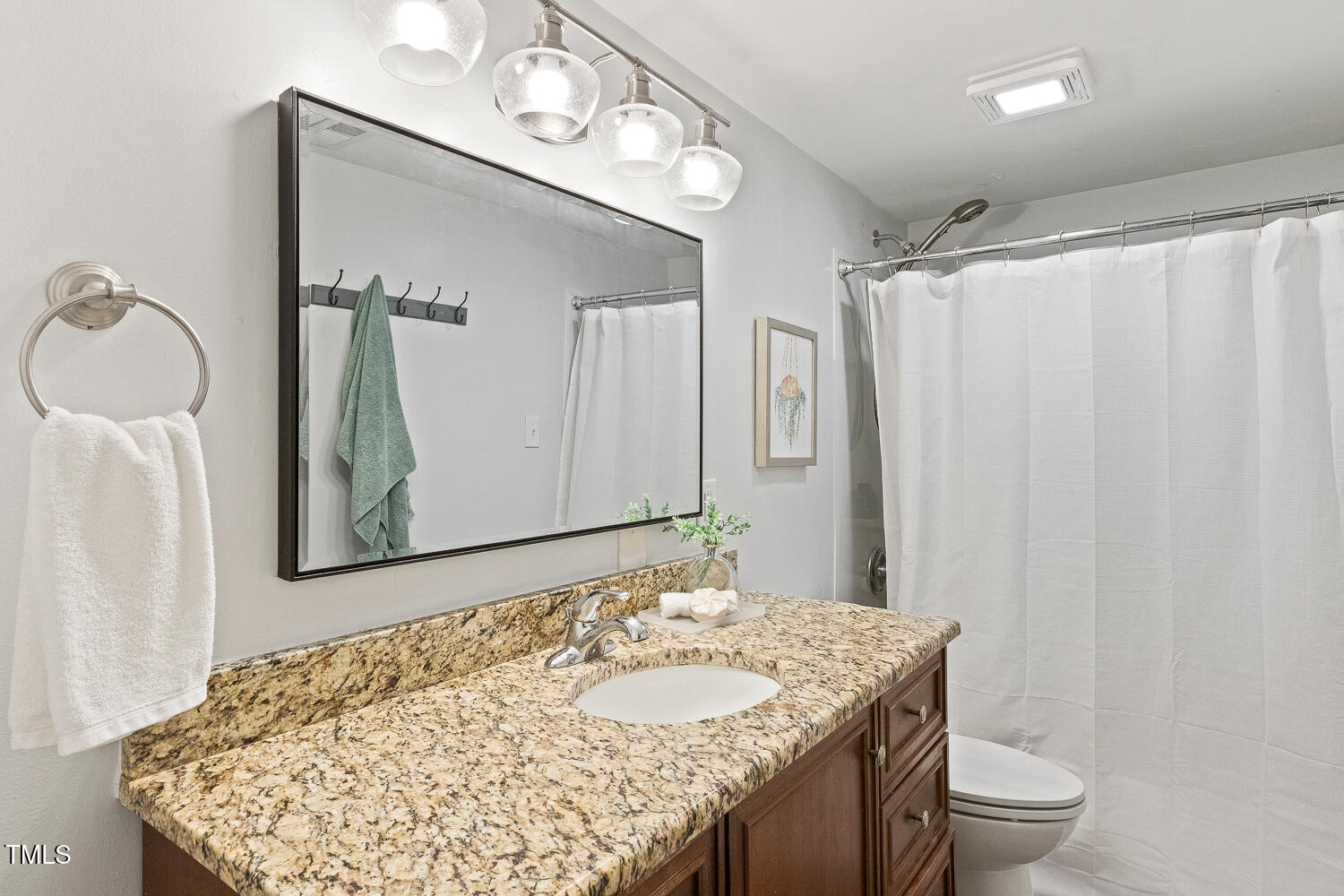7002 Longstreet Drive, Unit C Raleigh, NC 27615 - Photo 24 of 31 a bathroom with a granite countertop sink and a mirror