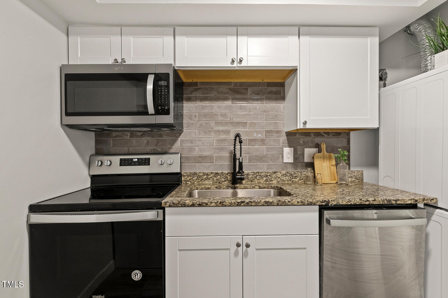 7002 Longstreet Drive, Unit C Raleigh, NC 27615 - Photo 10 of 31 a kitchen with stainless steel appliances granite countertop a stove microwave and sink