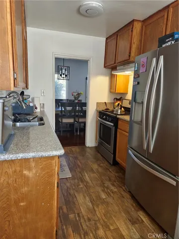 a kitchen with stainless steel appliances granite countertop a refrigerator a stove and a sink