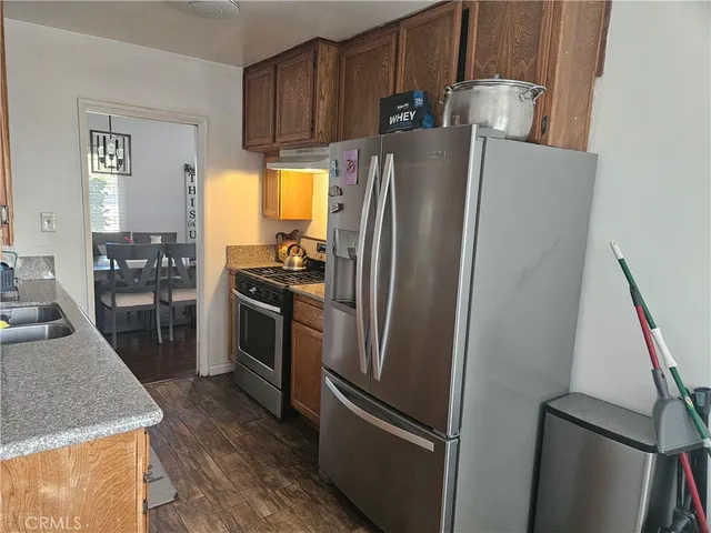 a kitchen with stainless steel appliances granite countertop a refrigerator and a stove