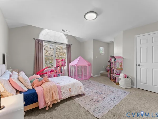 a bed sitting in a bedroom next to a window with a dresser