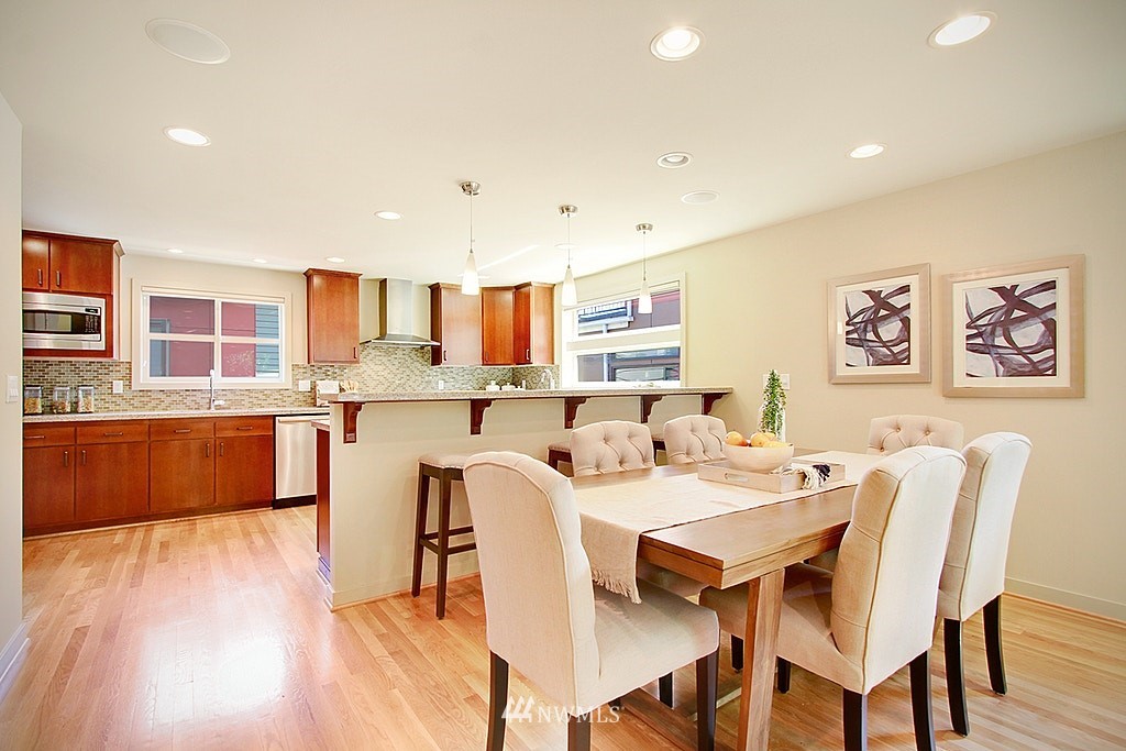 7757 Sand Point Way Northeast, Unit A Seattle, WA 98115 - Photo 11 of 25 a view of a dining room with furniture and wooden floor