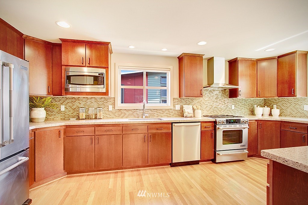 7757 Sand Point Way Northeast, Unit A Seattle, WA 98115 - Photo 3 of 25 a kitchen with stainless steel appliances granite countertop a stove and a sink