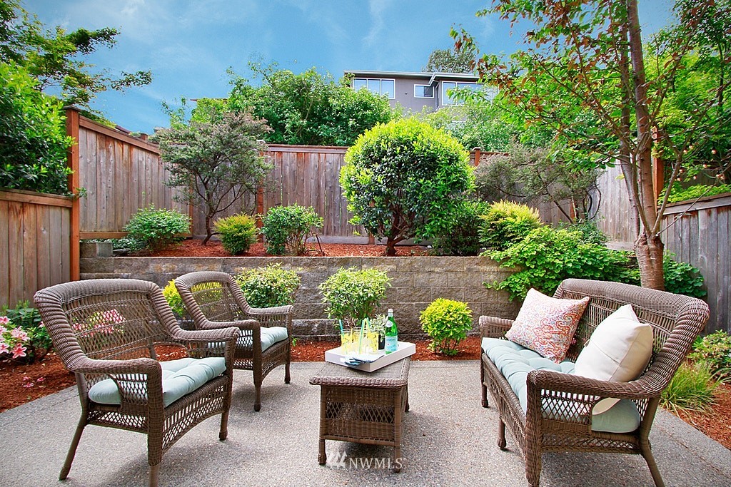 7757 Sand Point Way Northeast, Unit A Seattle, WA 98115 - Photo 25 of 25 a view of a patio with couches table and chairs potted plants and palm tree
