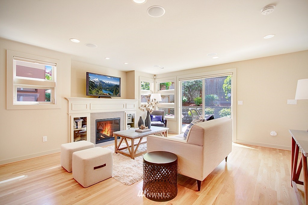 7757 Sand Point Way Northeast, Unit A Seattle, WA 98115 - Photo 8 of 25 a living room with fireplace furniture and a large window