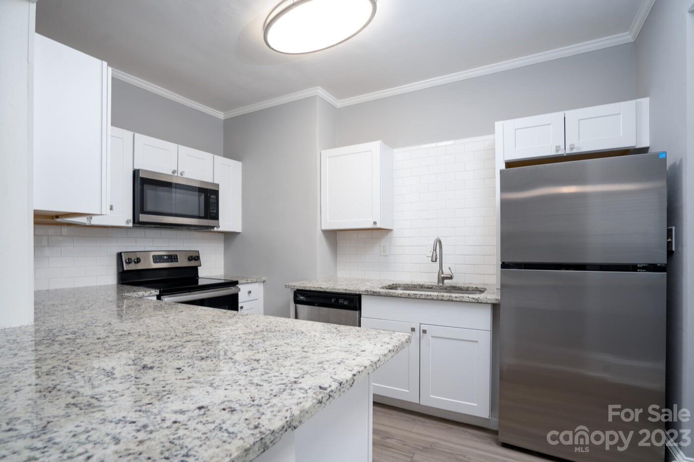 228 Providence Road Charlotte, NC 28207 - Photo 8 of 16 a kitchen with stainless steel appliances granite countertop a refrigerator a stove a sink and a microwave