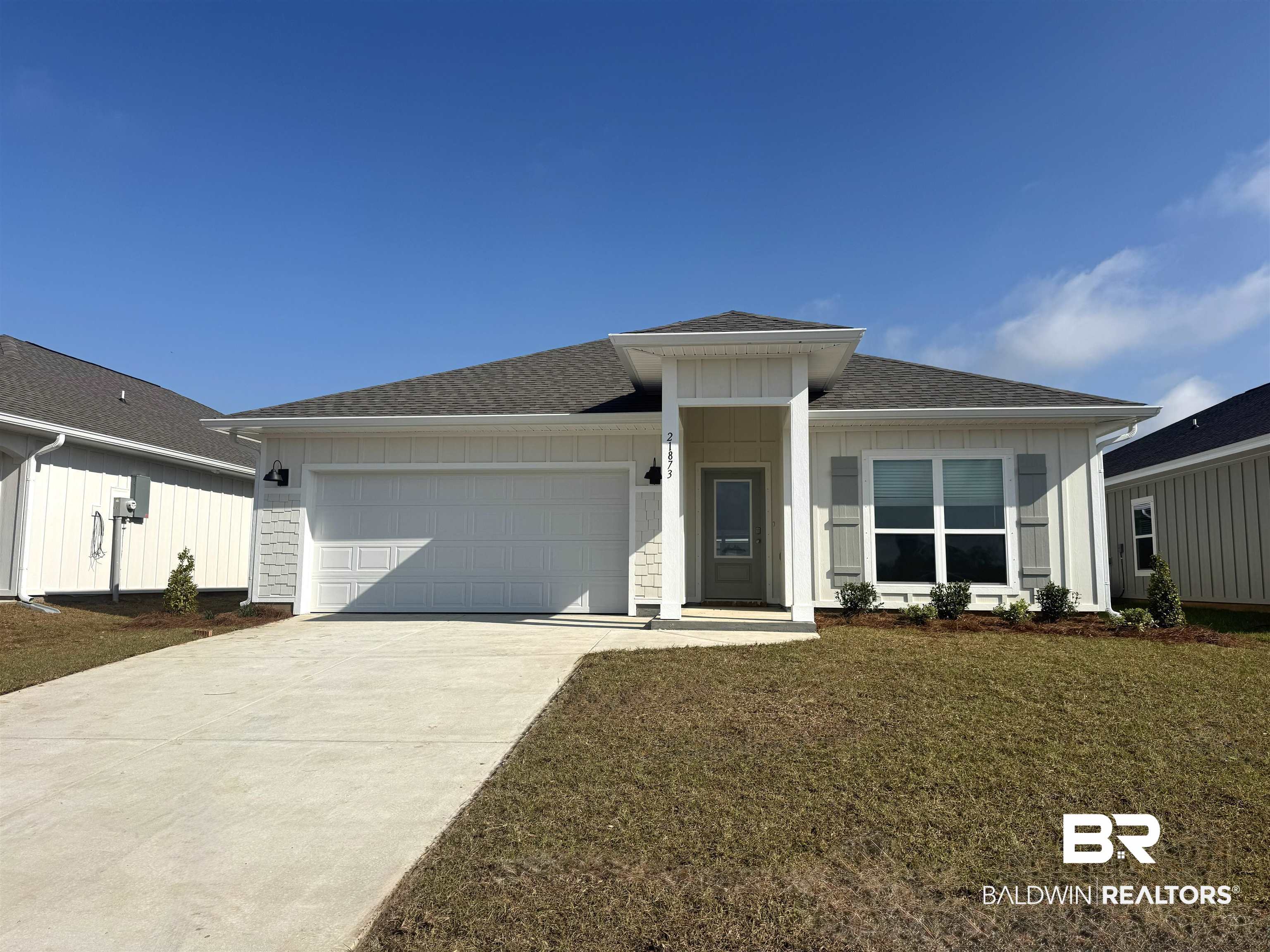 21873 Seabrooke Avenue Foley, AL 36535 - Photo 1 of 40 View of front of house with an attached garage, roof with shingles, driveway, board and batten siding, and a front lawn