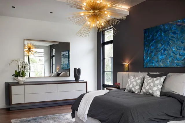 a bedroom with a large bed and a chandelier