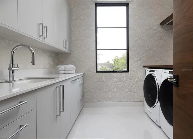 a utility room with sink dryer and washer