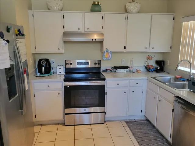 a kitchen with stainless steel appliances a stove a sink and a refrigerator