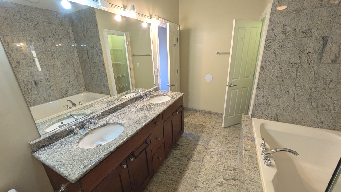1355 West Washington Boulevard, Unit 6B Chicago, IL 60607 - Photo 17 of 28 a spacious bathroom with a granite countertop sink a mirror and a shower