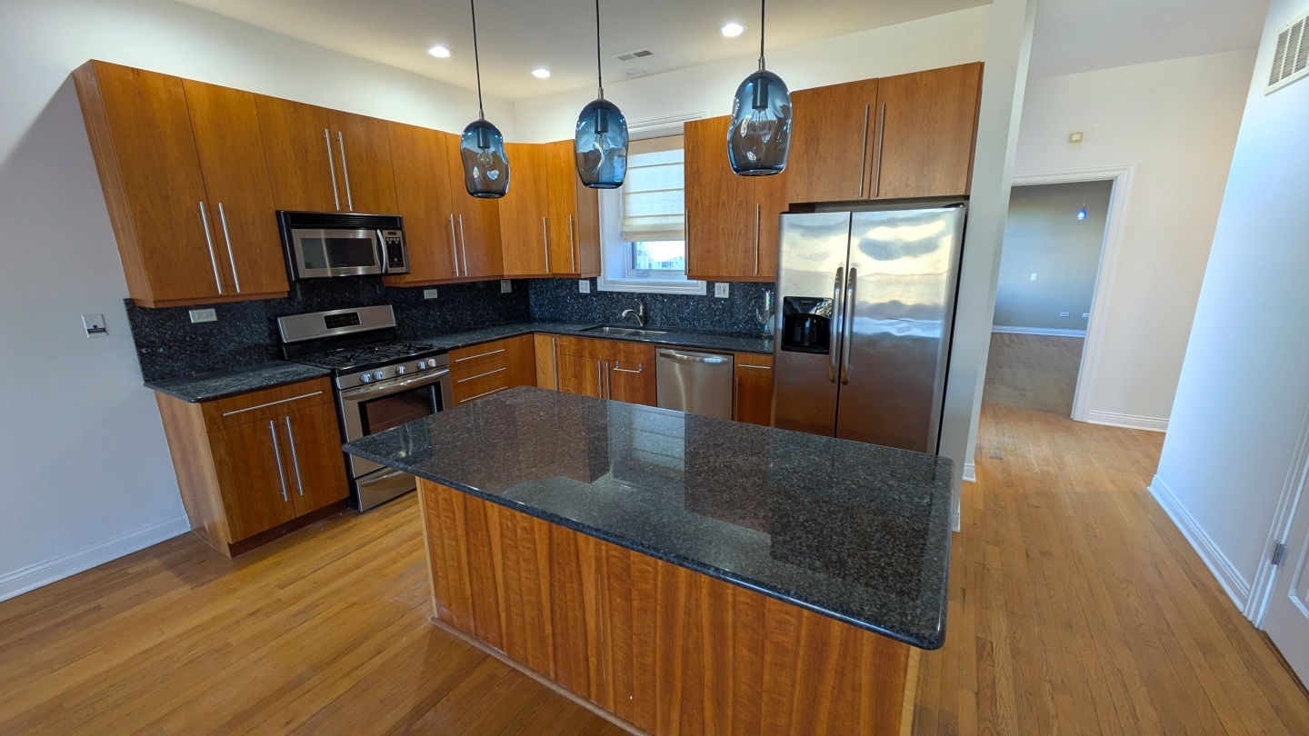 1355 West Washington Boulevard, Unit 6B Chicago, IL 60607 - Photo 9 of 28 a kitchen with stainless steel appliances granite countertop a sink a stove top oven a refrigerator and dishwasher with wooden floor