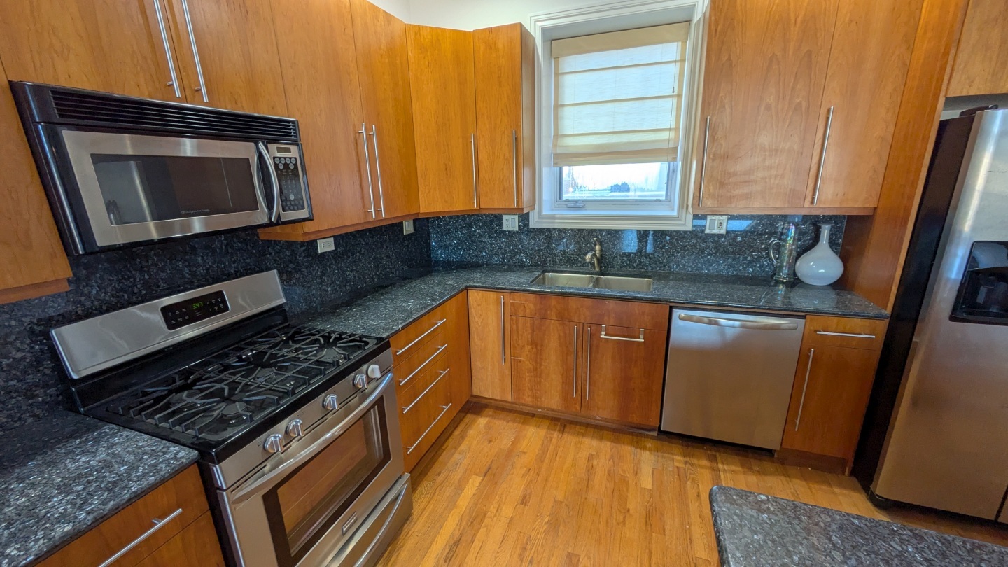1355 West Washington Boulevard, Unit 6B Chicago, IL 60607 - Photo 10 of 28 a kitchen with granite countertop a sink a stove microwave and cabinets