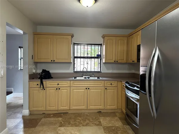 a kitchen with stainless steel appliances granite countertop a refrigerator sink and stove
