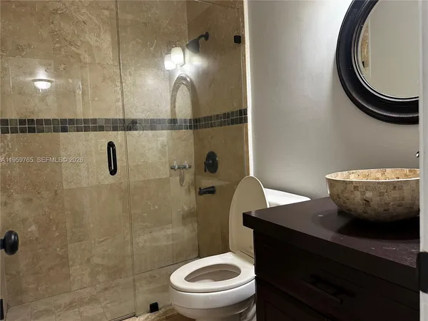 a bathroom with a toilet a sink and mirror