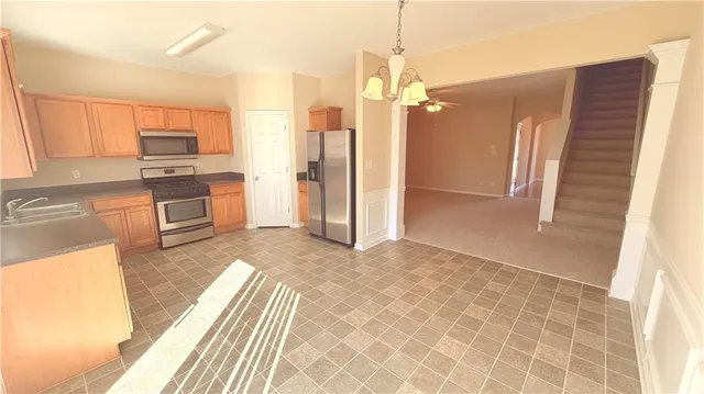 a kitchen with stainless steel appliances granite countertop a refrigerator and a sink